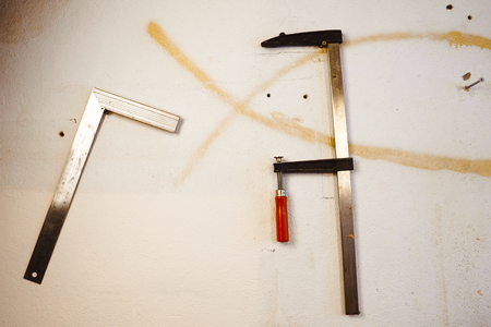construction ruler and clamps hanging on the wall