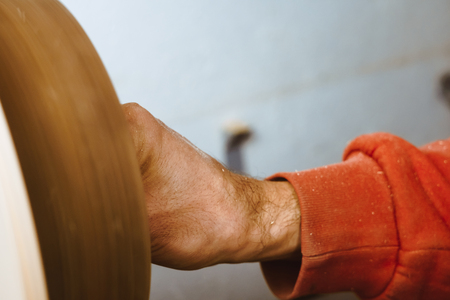 Wood turners using sandpaper polished wood on a latheの写真素材