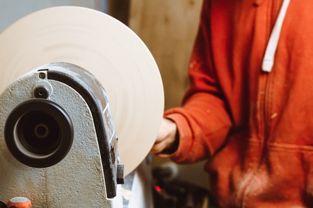 the worker turns the wood on a lathe in his workshopの写真素材