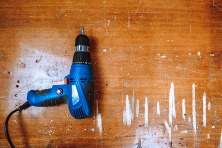 Electric hammer drill lies on a wooden tableの写真素材