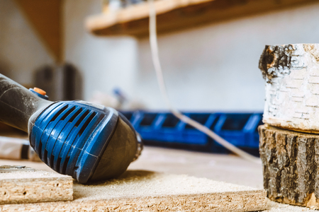 Electric hammer drill lies on a wooden tableの写真素材