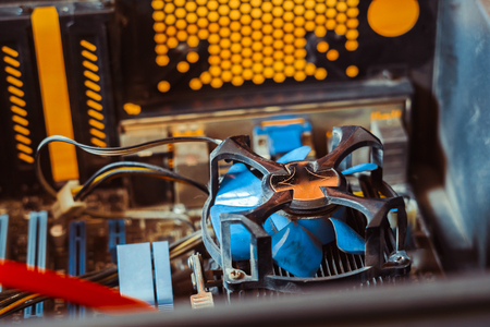 Dust on the computer pc processor cooler with mainboard and computer case fragment. Selective focus.