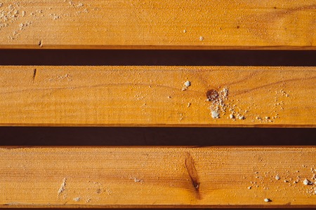 Wooden background of the benches with snow on the streetの写真素材