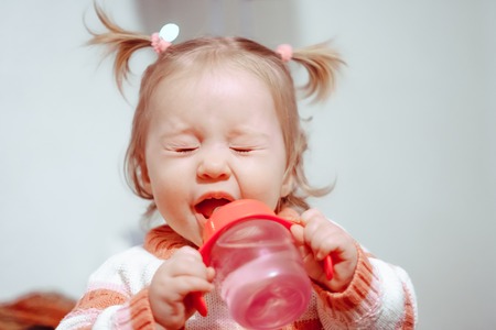 Cute little girl drinking water in summerの写真素材