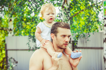 father with kid on the neck closing parent's eyesの写真素材