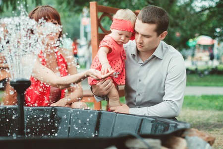 Woman with child playing against splashes of water in the summerの写真素材