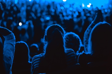 the viewer sits on the concert back, silhouetteの写真素材