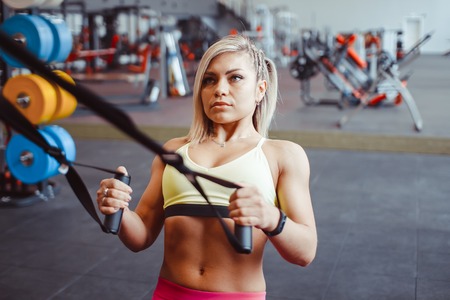 beautiful woman is doing exercises in the sport club.