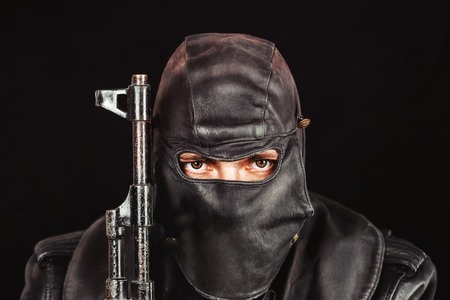 terrorist in a leather mask holding a knifeの写真素材