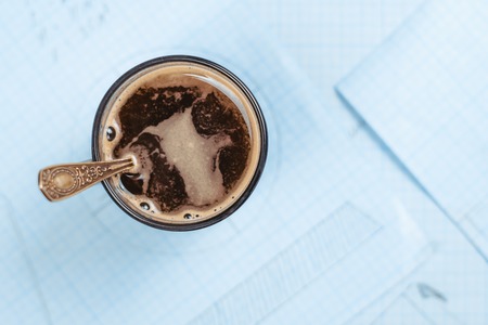 a Cup of coffee is on paper with drawingsの写真素材