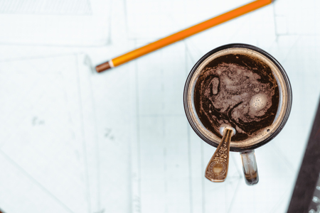 a Cup of coffee is on paper with drawingsの写真素材