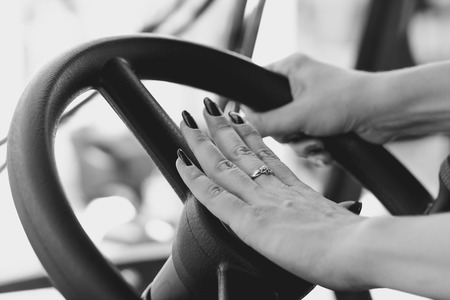 women's hand holding the steering wheel of a truckの写真素材