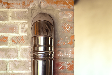 iron pipe of the fireplace of the house in a brick wallの写真素材