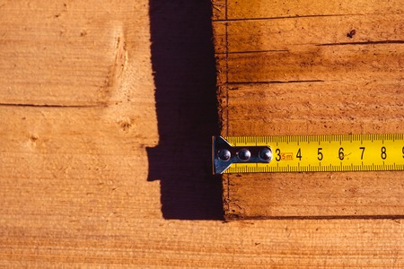 tape measure on the brown wooden backgroundの写真素材