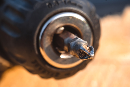 Screw being screwed into a piece of wood by cordless drill. Concept tools and repair work.の写真素材