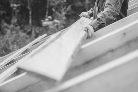 worker roofer builder working on roof structure on construction siteの写真素材