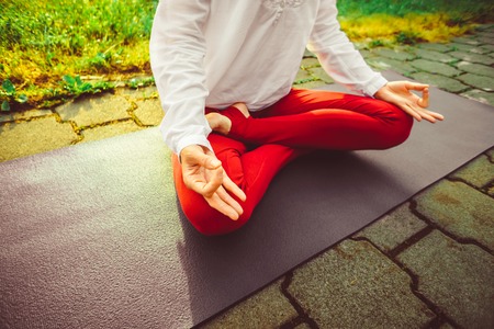 Pretty woman doing yoga exercises in the parkの写真素材