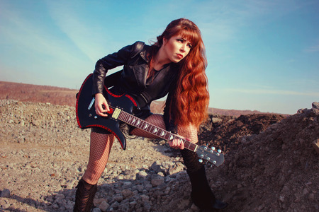 beautiful girl in leather jacket with guitarの写真素材