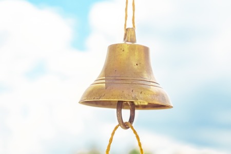 the bell hangs on a rope against the skyの写真素材