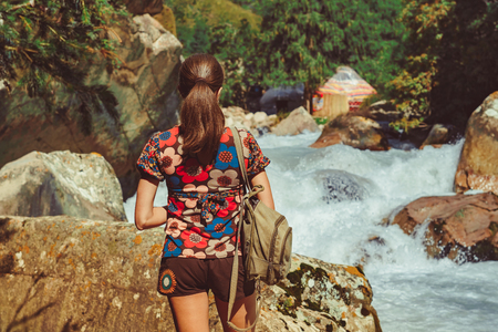 woman traveler with backpack looking at amazing mountains and river, concept of traveling wandering lust, space for text, atmospheric epic momentの写真素材