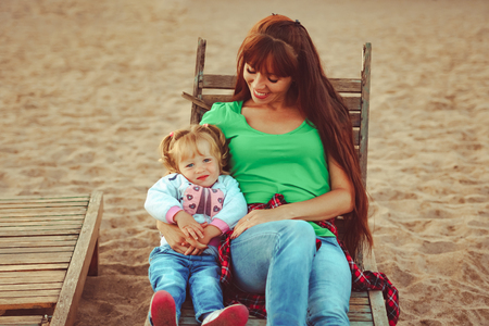mom and daughter on the beach lying on the sun loungersの写真素材