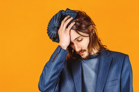 people, health problem and stress concept - unhappy indian man suffering from headache over grey backgroundの写真素材