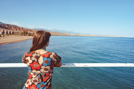 Pretty long hair brunette girl relaxing on the pier near lakeの写真素材