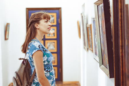 Novokuzneck, Russia - 01.09.2018: Young woman looking at modern painting in art galleryのeditorial素材