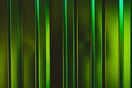 Metal plate fence, sun shining from side. Abstract construction background.
