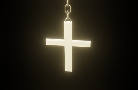Golden 3D Christian cross on a chain hanging in the darkの写真素材