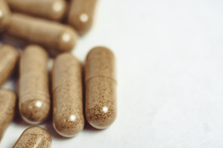 Scattered orange pills on white background right on topの写真素材