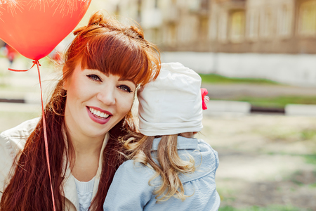 mom and daughter holding a balloon in the Parkの写真素材