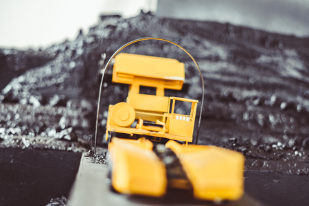 toy yellow tractor in the scenery of coal miningの写真素材