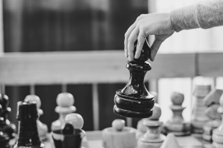 hand holding a large chess piece over the Boardの写真素材