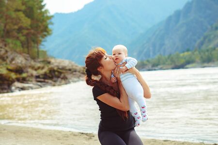 my mother raises a son in his arms laughing upwardsの写真素材