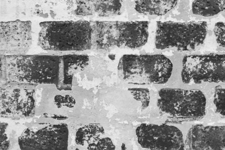 the texture of an old brick wall peeling plasterの写真素材