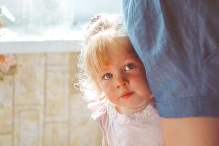 the child hides behind his motherの写真素材