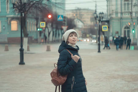 a girl in a winter hat walks around the cityの写真素材