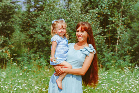 mom hugs her daughter in natureの写真素材