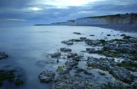 Sunst over white cliffs with smooth sea and rocksの写真素材