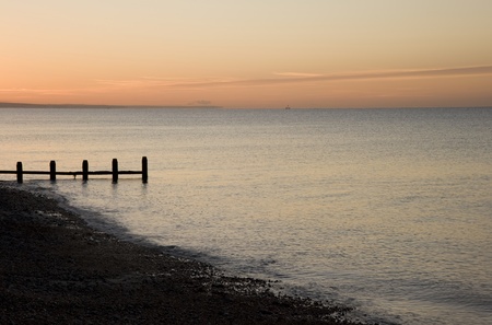 Beautiful long exposure sunrise over beach and vibrant skyの写真素材