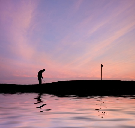 Silhouette of man playing golf on beautiful colorful sunsetの写真素材