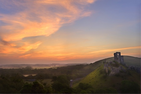 Beautiful dreamy fairytale castle ruins against romantic colorful sunriseの写真素材
