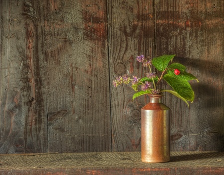 Still life image of dried flowers in rustic vase against weathered wooden backgroundの写真素材
