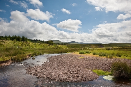 Beautiful landscape across countryside to mountains in distance with moody sky