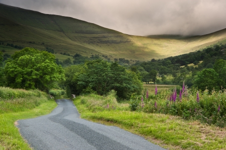 Beautiful landscape across countryside to mountains in distance with moody sky