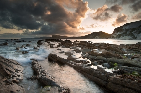 Beautiful sunrise landscape over Mupe Bay on Jurassic Coast in Dorset, Englandの写真素材