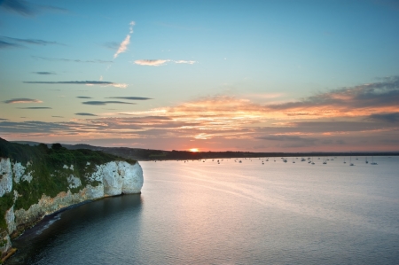 Beautiful sunset with cliffs surrounding bay and yachts silhouettedの写真素材
