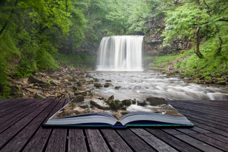 Creative composite image of waterfall in woods in pages of magic bookの写真素材
