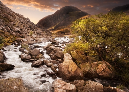 Dramatic sunset with beautiful sky over mountain range giving a strong moody landscape wiht flowing...